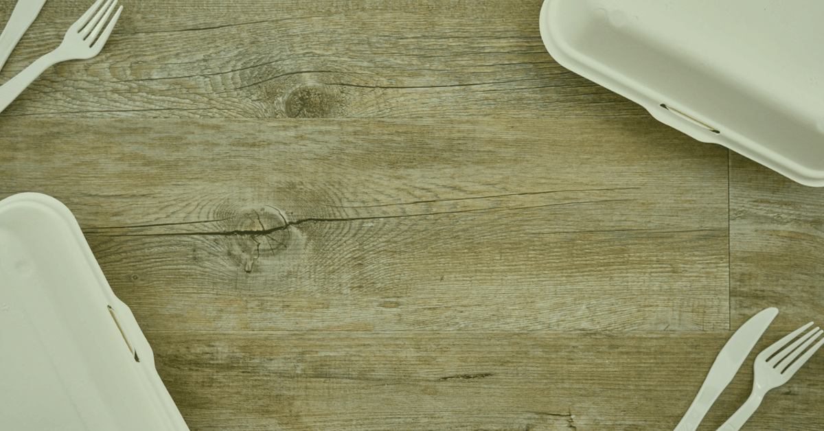 wood table with takeout containers and fork